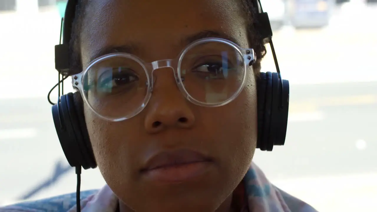 Female commuter listening music on headphones while travelling in bus 4k