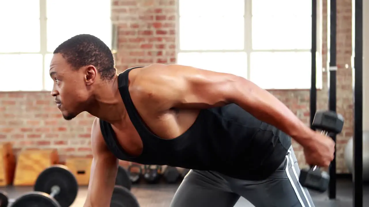 Fit man lifting heavy black dumbbell