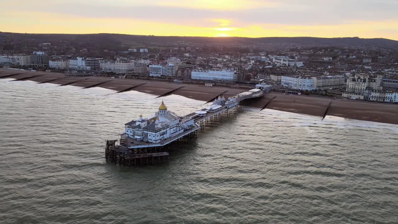 Eastbourne Pier and town at Sunset Sussex Uk Aerial pull back view 4K