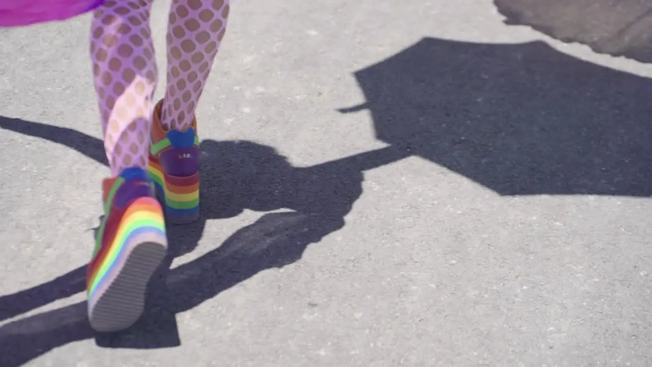 Feet of a person walking in the street day