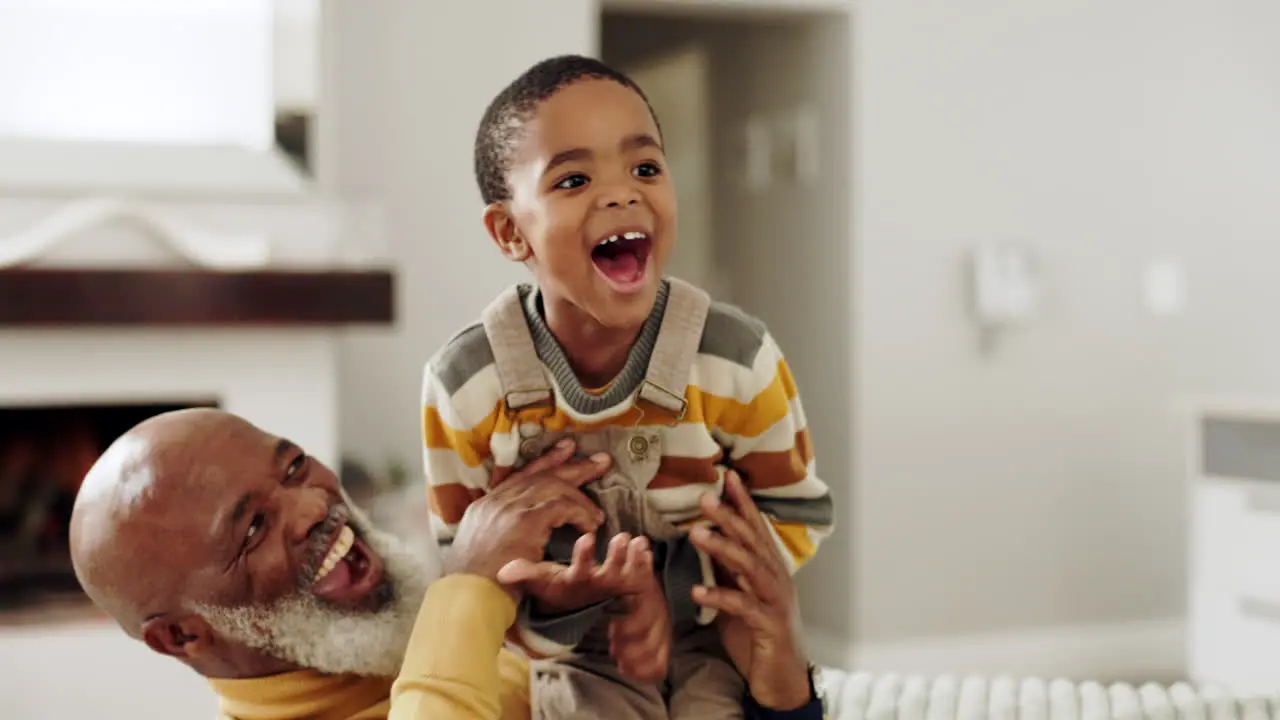 Playing grandfather and kid laughing on sofa