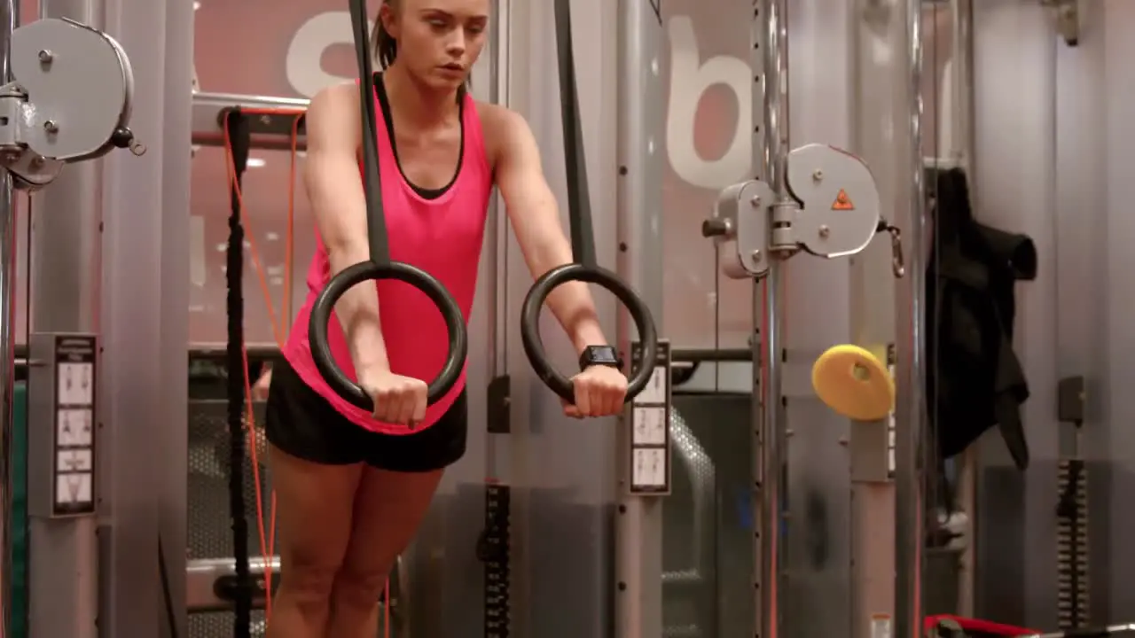 Woman using gymnastic rings in gym