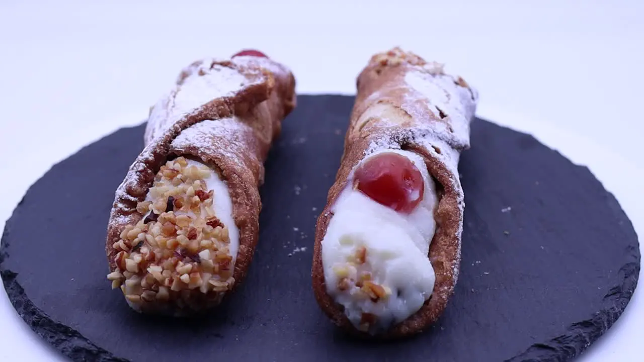 Cannolo Siciliano Sicilian cannoli filled with ricotta cream rotating on a turntable