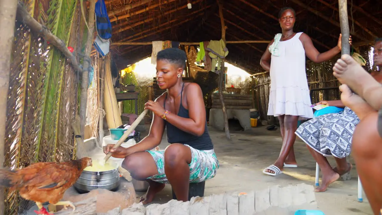 group of native black african woman preparing food together in remote rural fisherman village