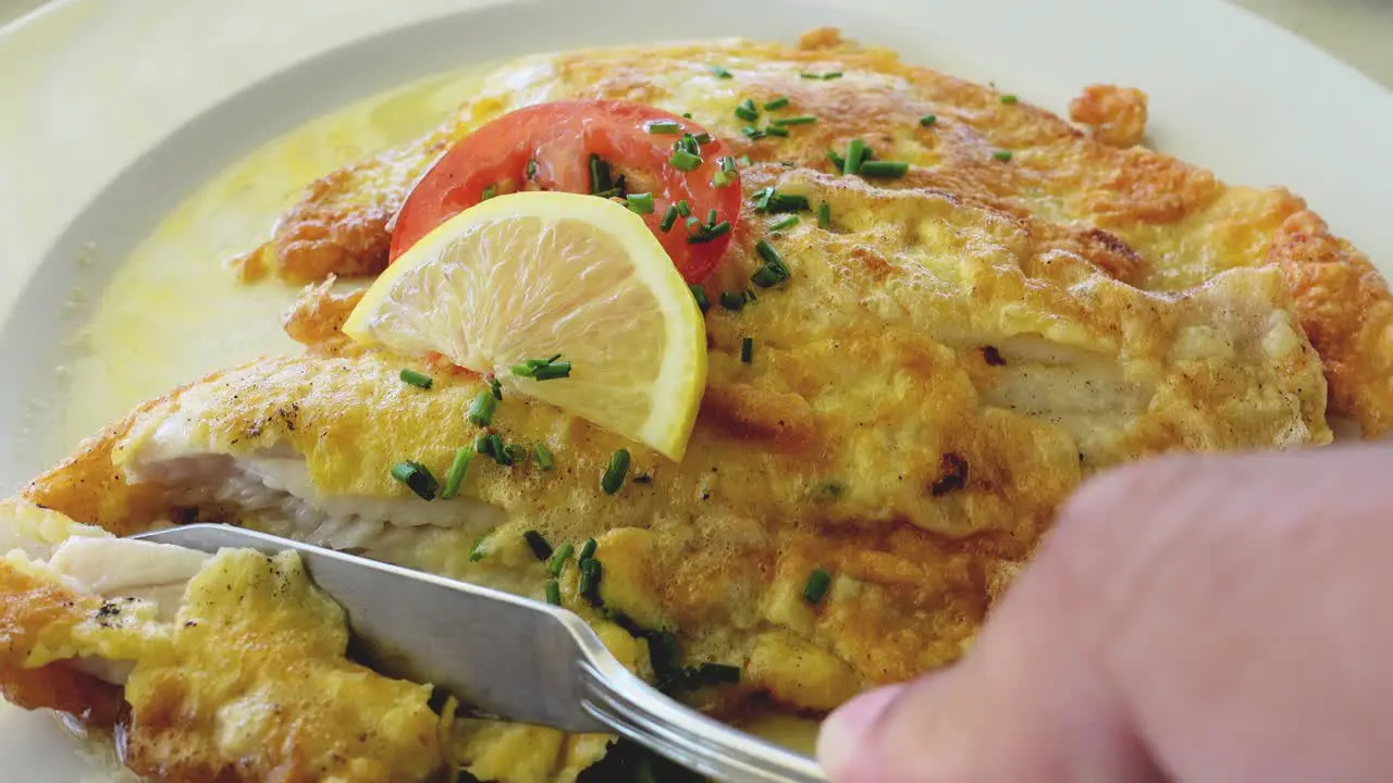 Eating fried white fish close up