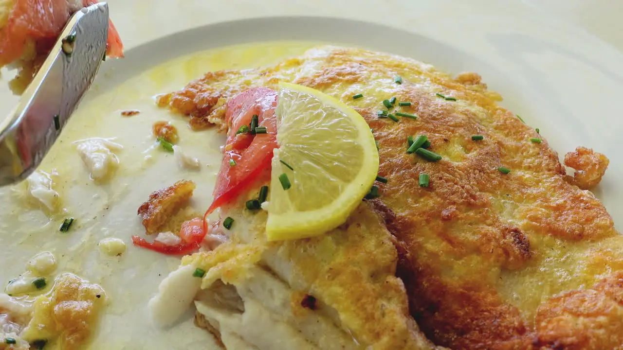 Close up of eating white fish fried in a delicate egg hull