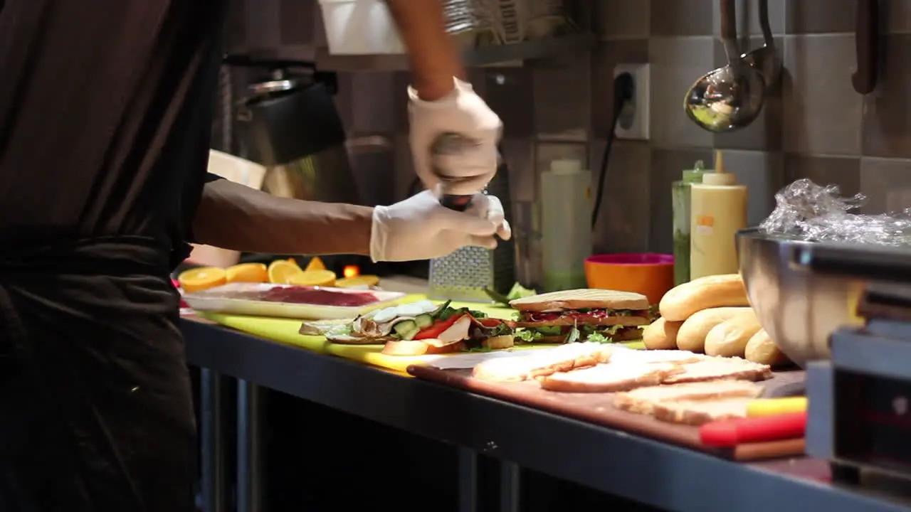 Caterer putting pepper on sandwich