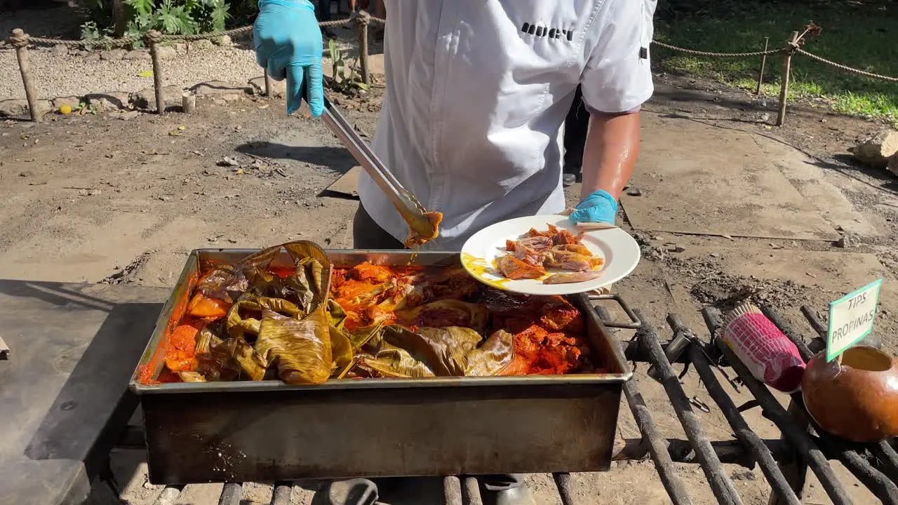 slow motion shot of chefs serving the tray of cochinita pibil