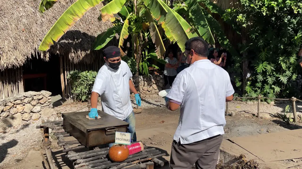 slow motion shot of chefs opening tray of cochinita pibil