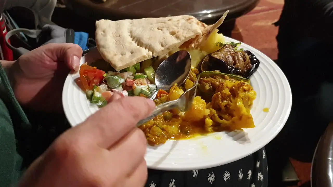 Close up of person eating a plate of delicious traditional Jordanian food with flat bread on their travels in Jordan Middle East