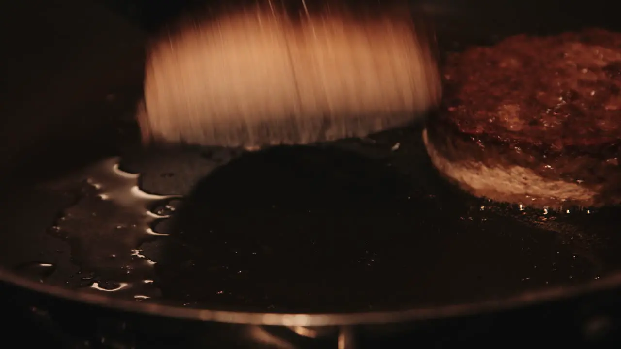 PlantBased Burgers Being Flipped while Cooking in Frying Pan