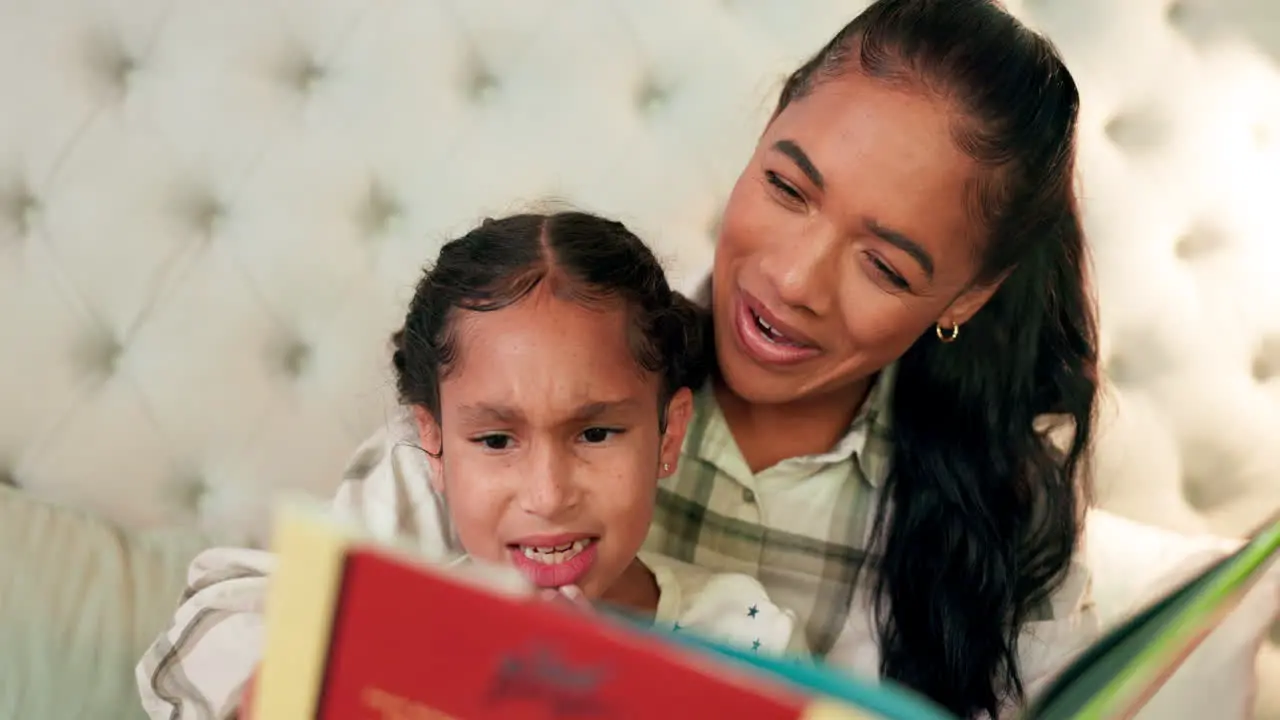 Reading mother and daughter in bedroom with book