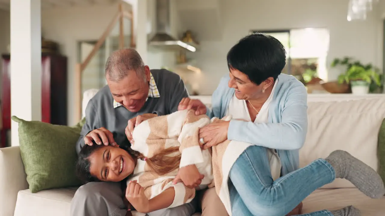 Laugh grandparents and girl playing on sofa