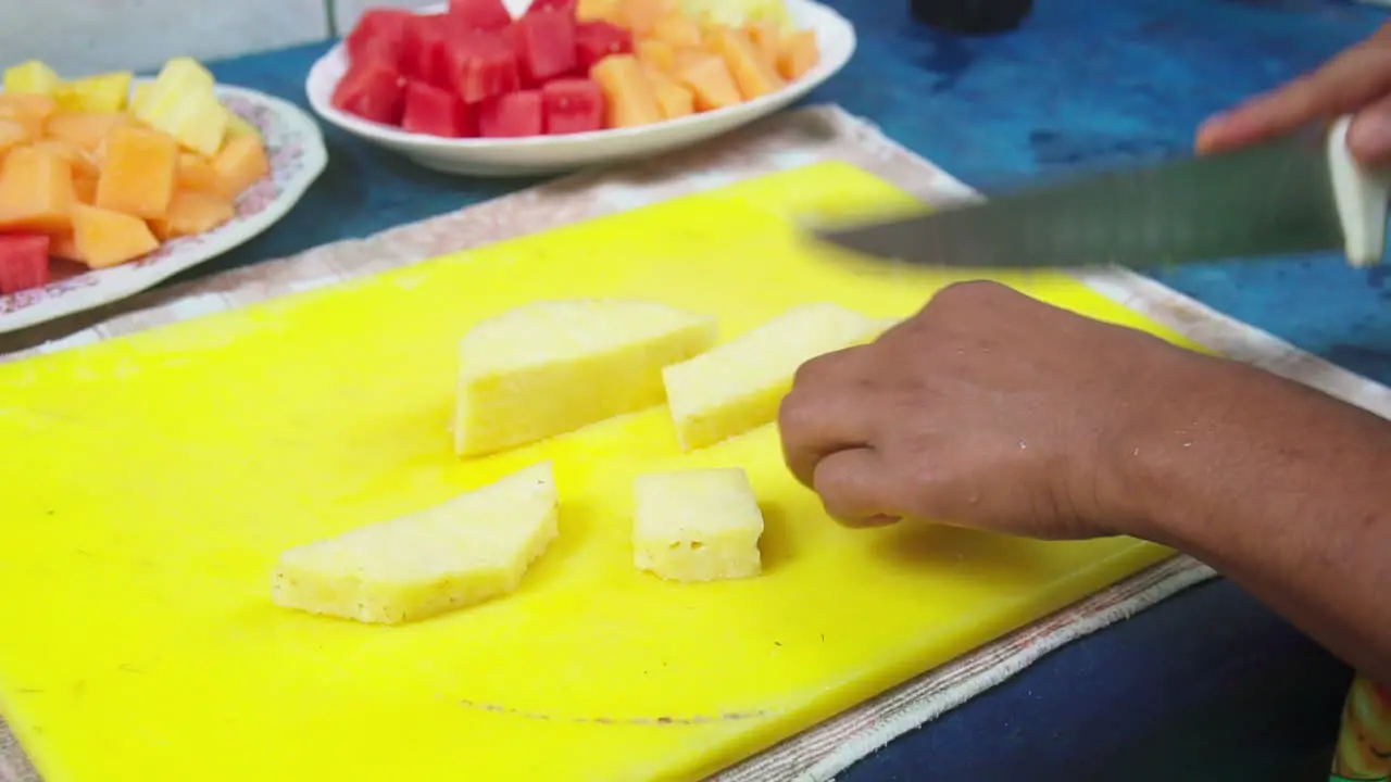 Close up of a knife cutting up pineapple while making fruit smoothies in Punta Banco Costa Rica