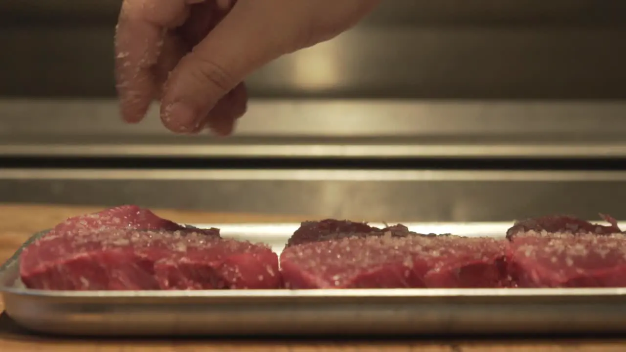 Salt sprinkle on raw tuna fillet in slowmotion close up macro