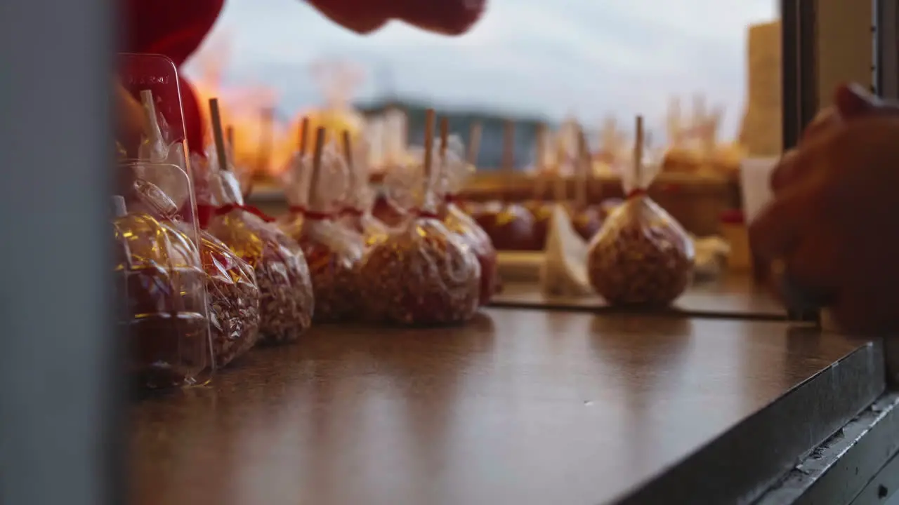 Woman cleaning countertop under candy apples in food truck