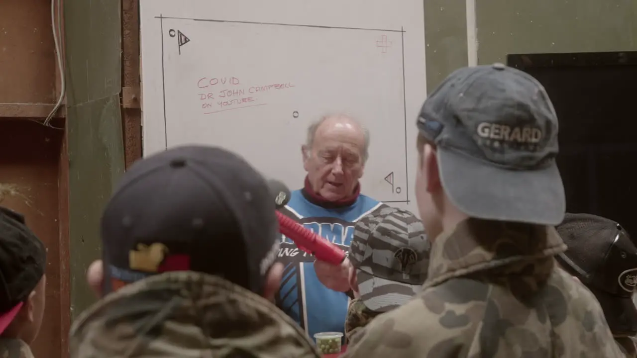 An instructor teaching students how to use a paintball gun