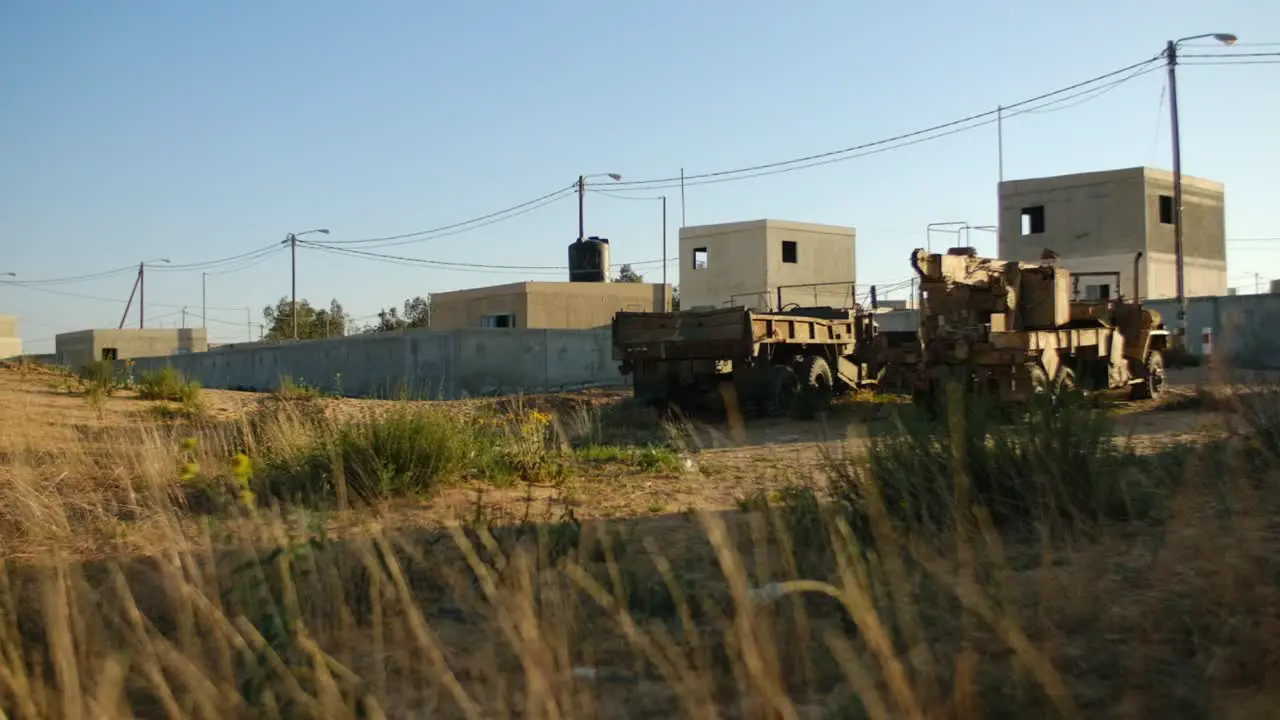 A desert area near a Palestinian city with scrap of military trucks lying in a field