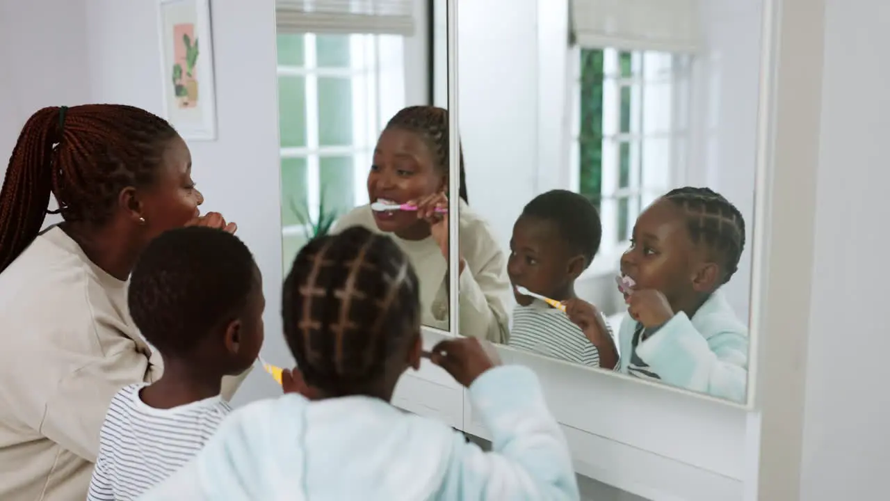 Mom children and brushing teeth at mirror