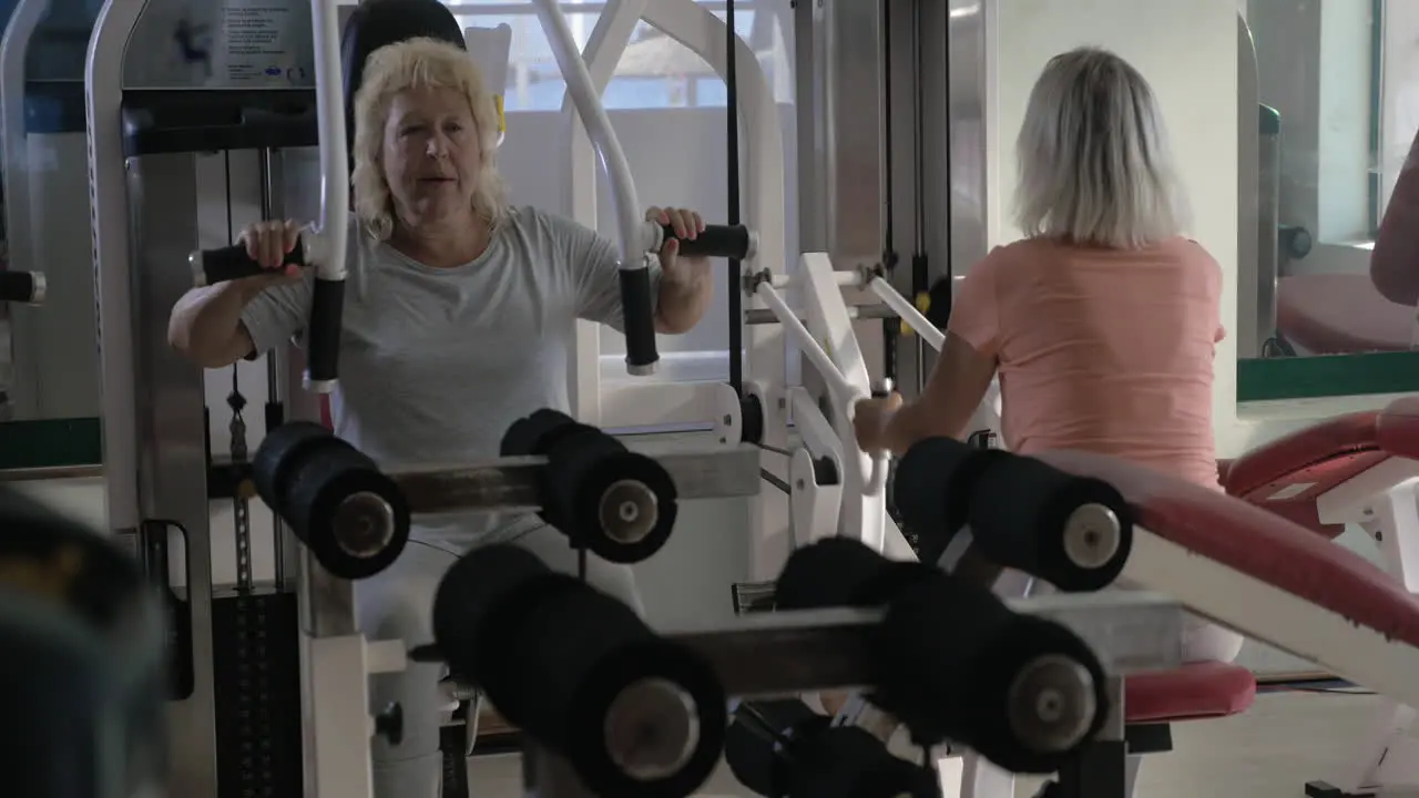 Senior women training on exercisers in the gym