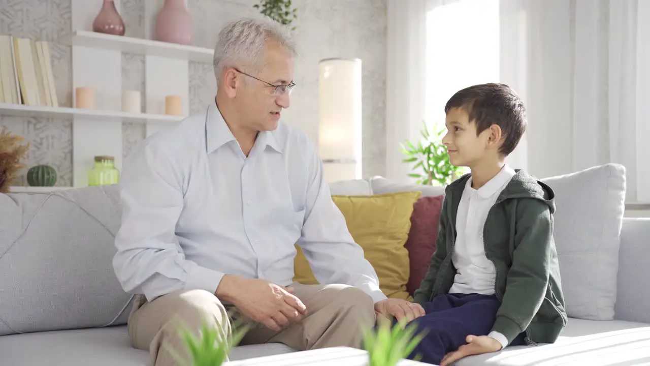 Father and son chatting and hugging at home