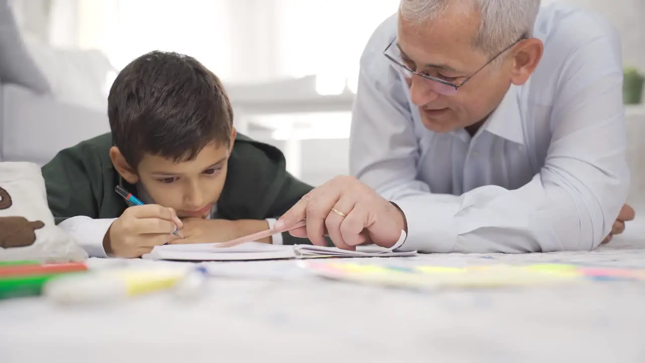 Father and son are reading a book together at home