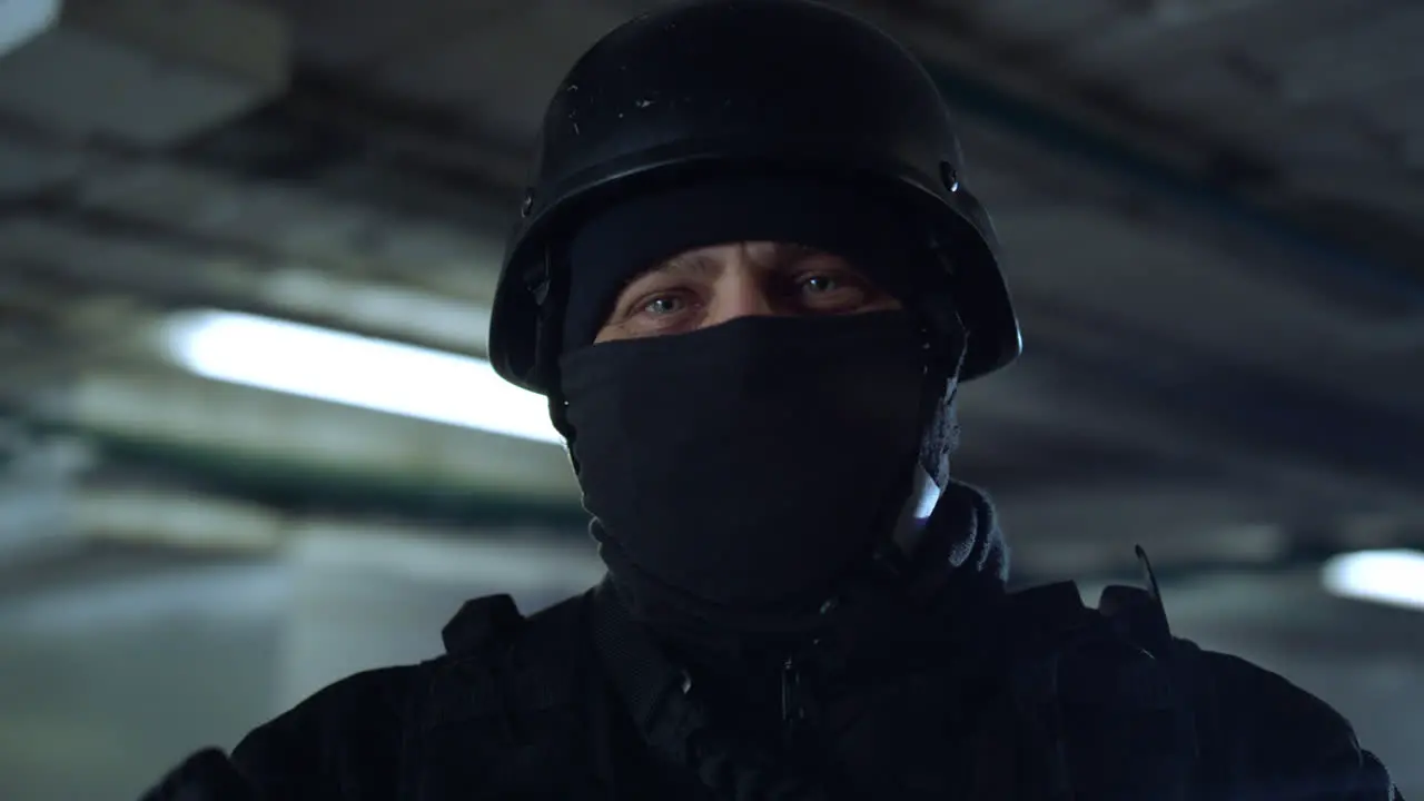 SWAT member standing in dark building Masked military soldier posing at camera