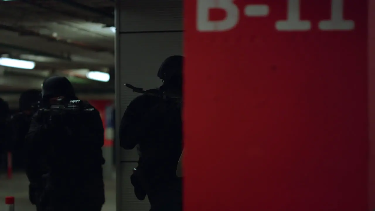 Soldiers hiding behind wall at operation SWAT police officers storming building