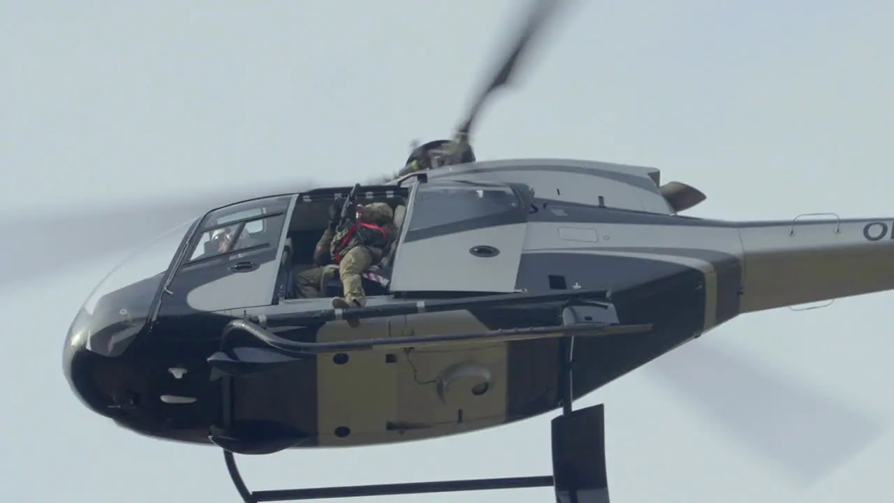 Military Helicopter Flying With Armed Soldier and Rifle Gun Special Force Training Low Angle