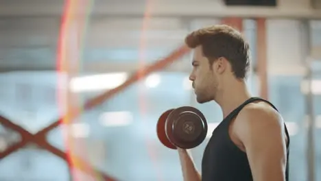 Athletic sport man practicing exercises with dumbbell in turn