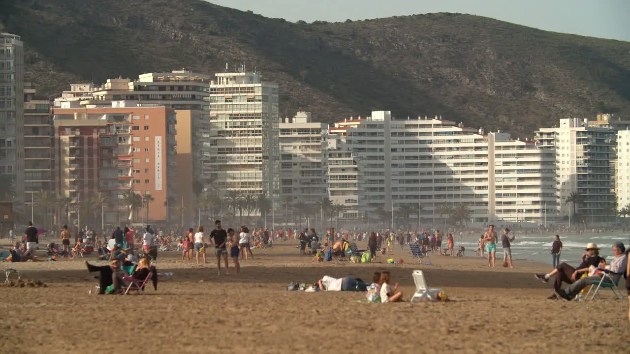 Crowded ocean beach with hotel building seaside resort