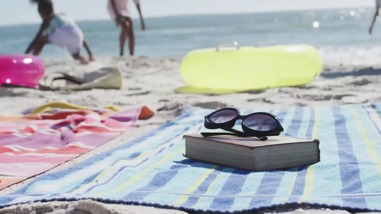 Video of sunglasses book towels and beach equipment lying on beach