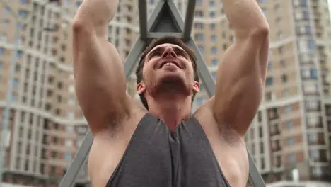 Close up of athlete man working out outdoor Fitness guy doing pull ups