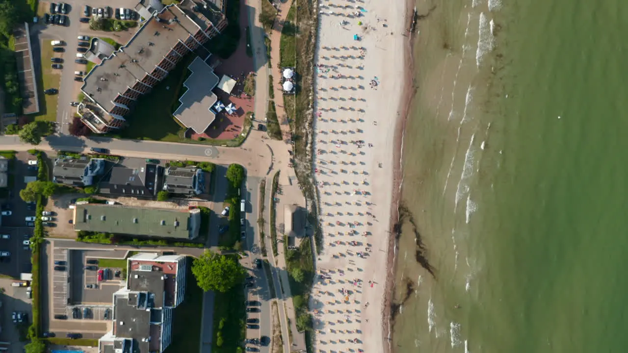 Aerial birds eye overhead top down view of tourist beach in Scharbeutz Germany Baltic sea forward day