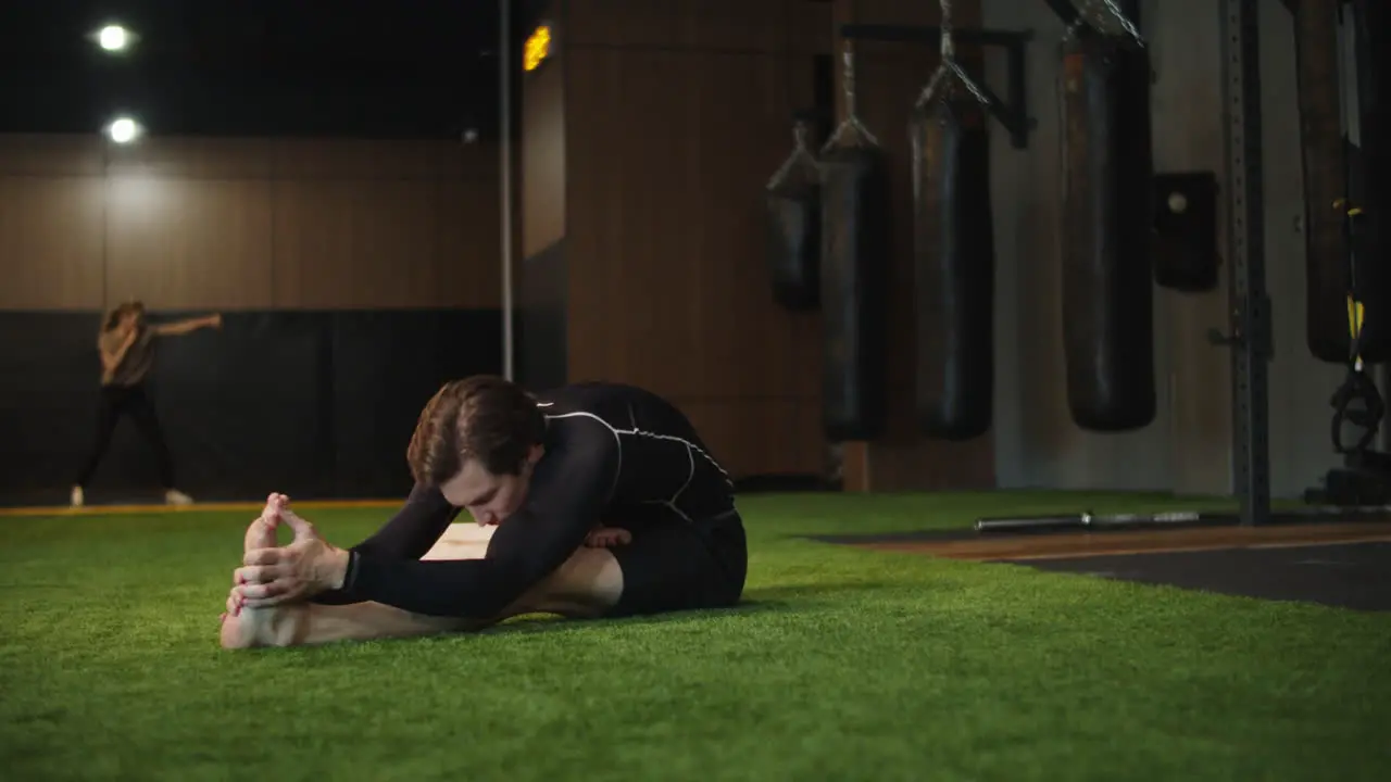 Active fitness man doing stretching in sport club Sport man exercising at gym