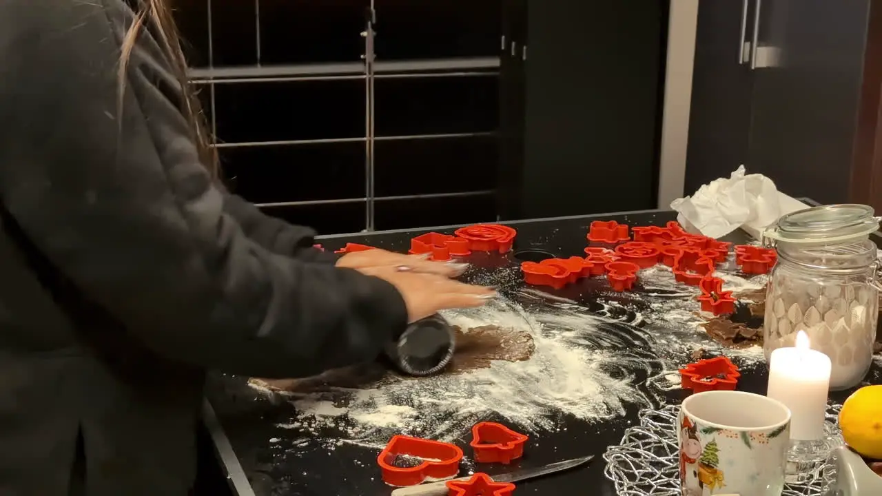 Making sweet gingerbread cookies for Christmas by chef on festive table