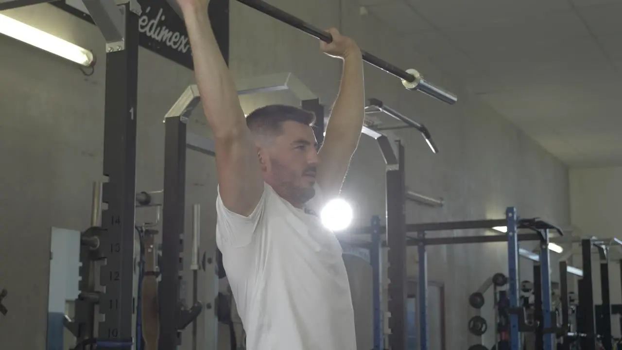 Muscular athlete holding a barbell in a gym