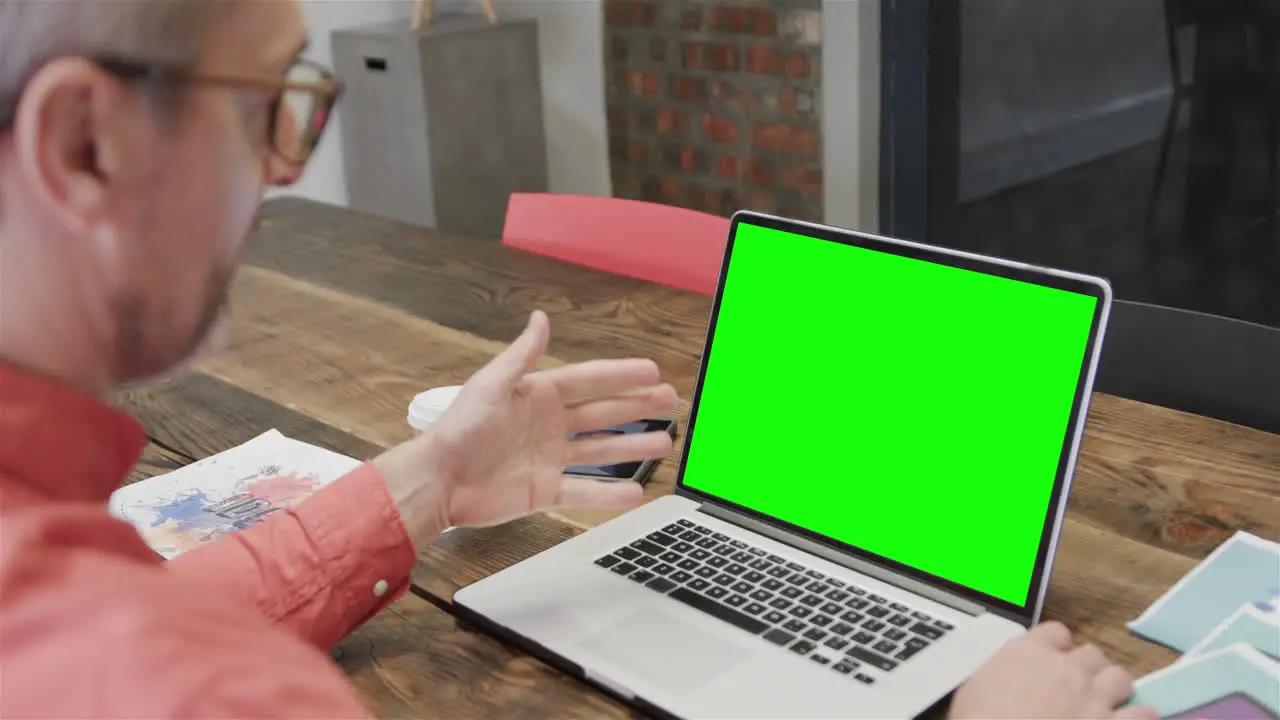 Caucasian businessman on laptop video call with green screen