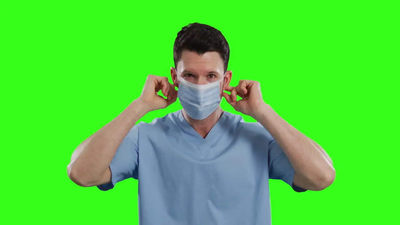 Caucasian male doctor wearing face mask on green screen background