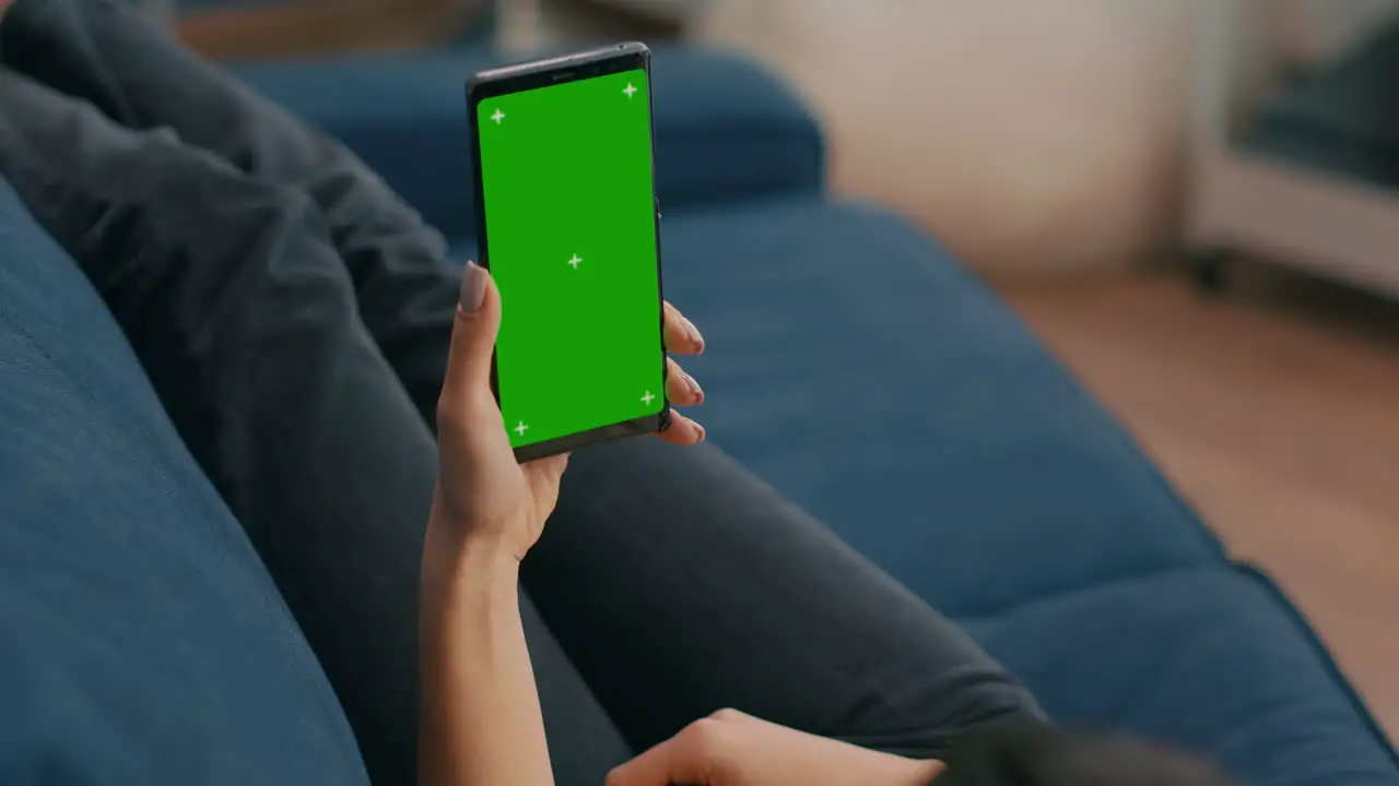 Freelancer holding in vertical mode smartphone with mock up green screen chroma key display