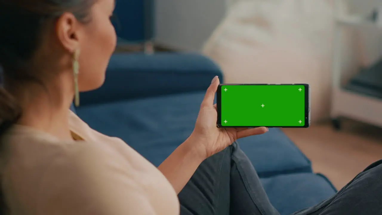 Close up of woman holding smartphone with mock up green screen chroma key display