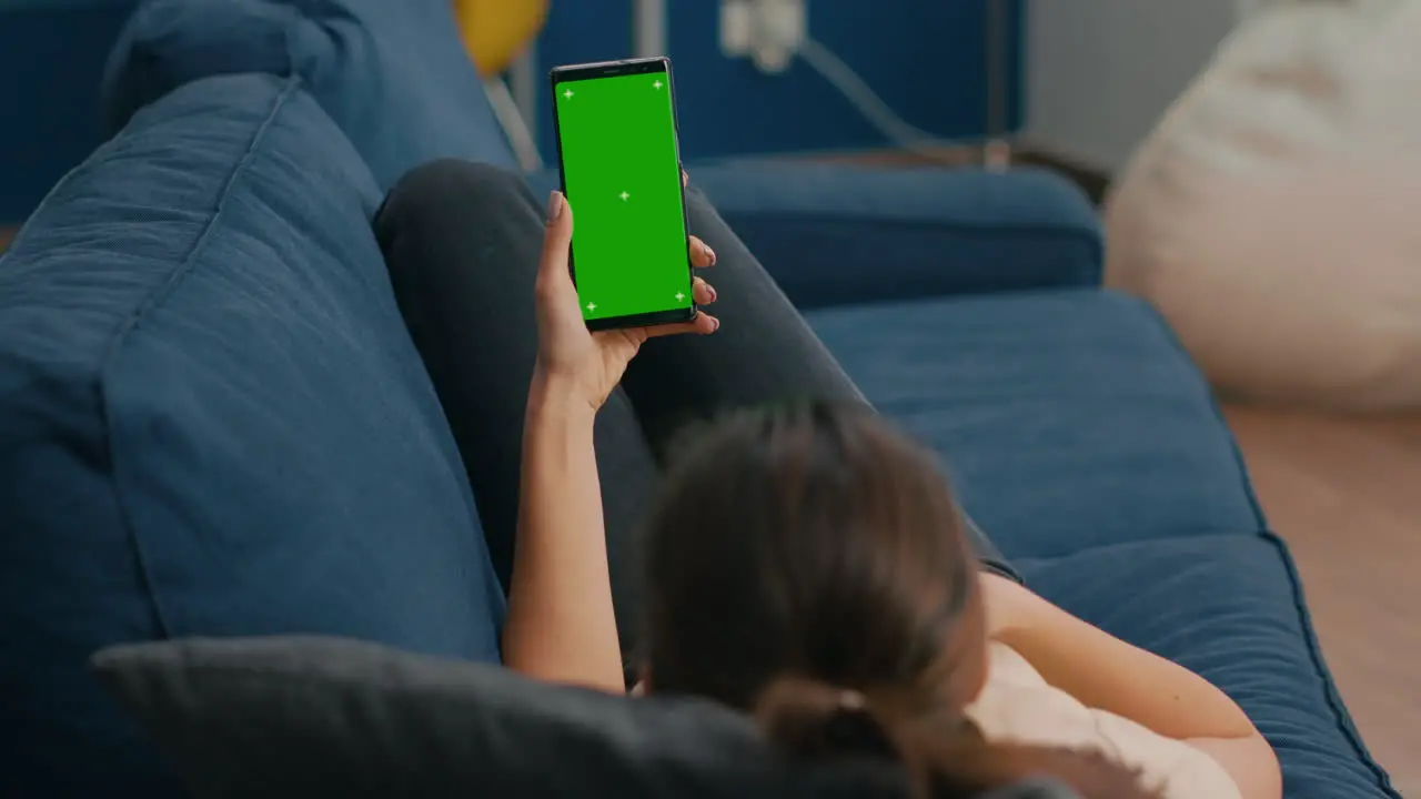 Freelancer lying on sofa while having online videocall on smartphone