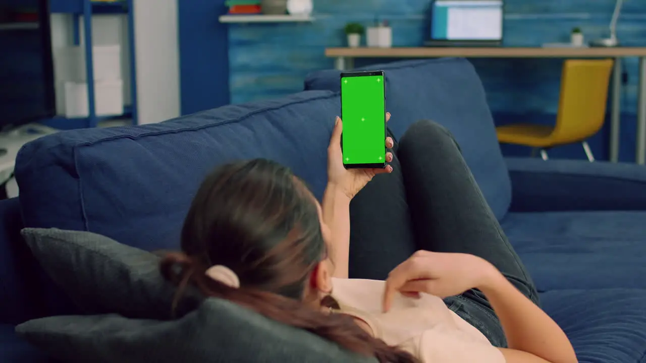 Casual woman holding smartphone with mock up green screen