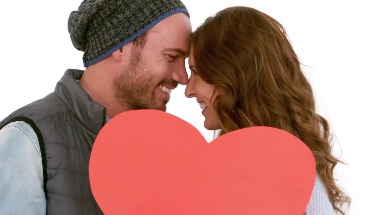 Young couple covering their face with a pillow heart