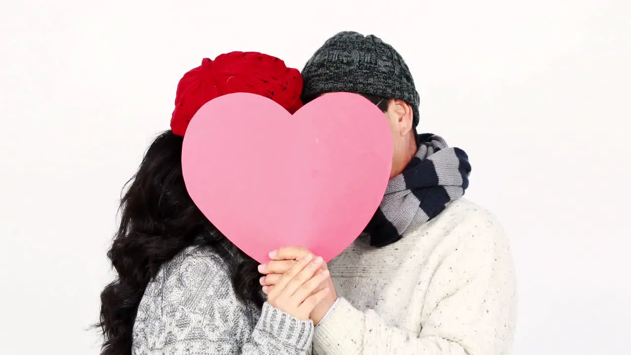 Mature Asian couple covering their face wit a pillow heart