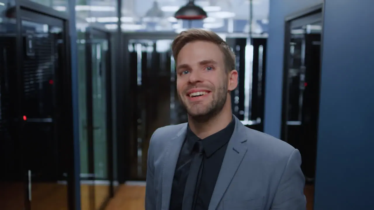 Handsome guy looking at camera in office Friendly man smiling in corridor