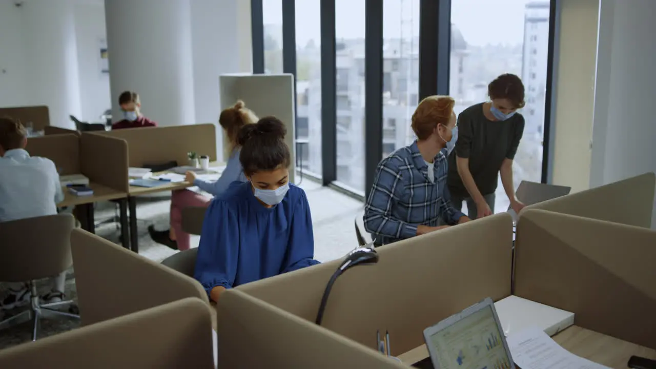 Employees in protective masks working in open space Team busy at workplace