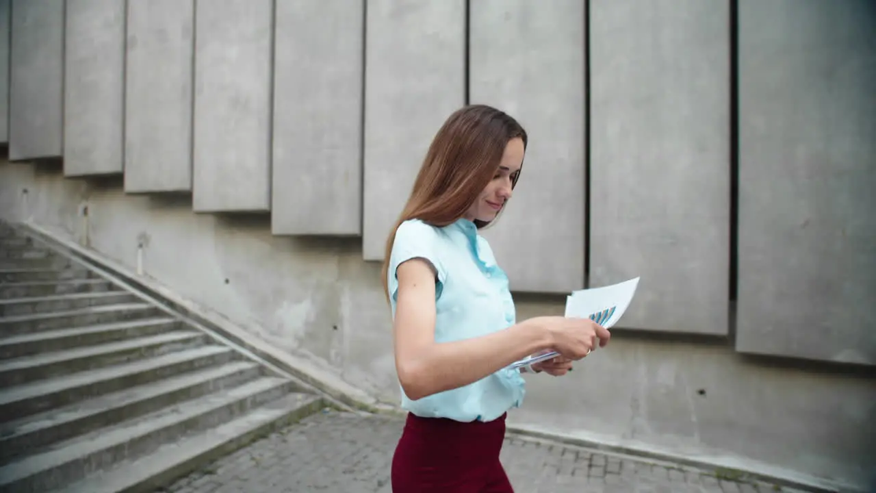 Businesswoman walking downstairs in city Woman working with business papers