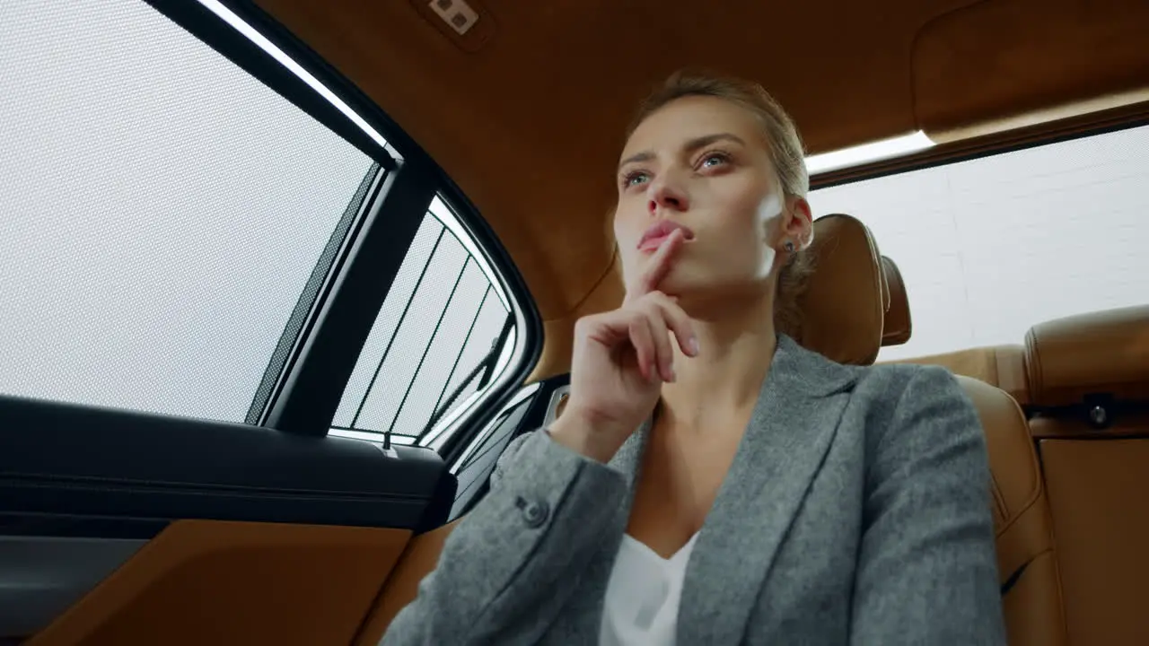 Focused business woman analysing at backseat Businesswoman thinking at car