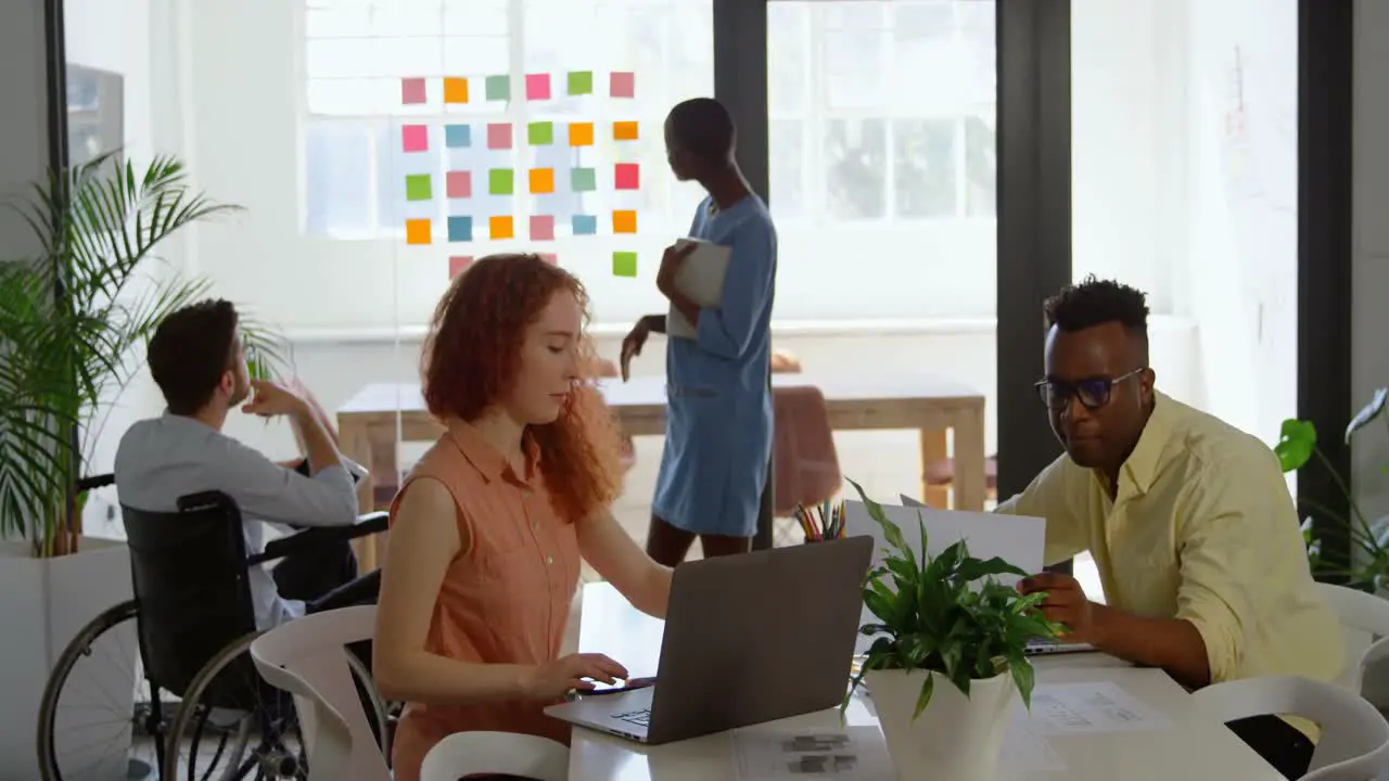 Side view of young mixed-race business team planning and working in a modern office 4k